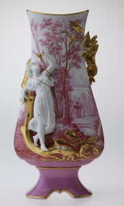 European porcelain vase with a tapering, bulbous rectangular body on foot. White underglaze with a red transfer print of a couple walking in a picturesque landscape. Includes a gilded relief mould of flowers, leaves and trees, and a white classical figure holding a gilded flower.